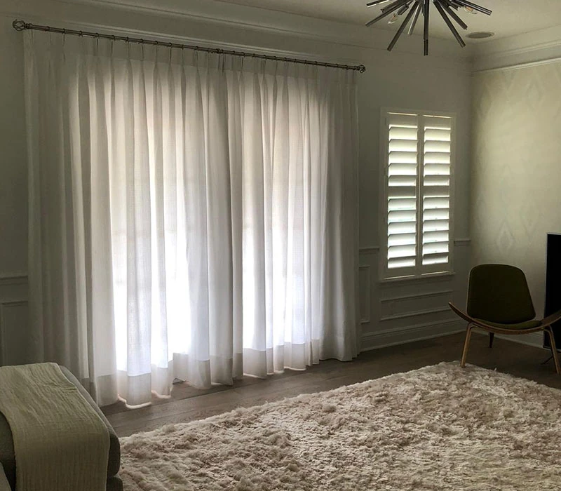 DecorSelis pinch pleat drapery in a luxury living room featuring elegant fabric fullness and tailored pleats.